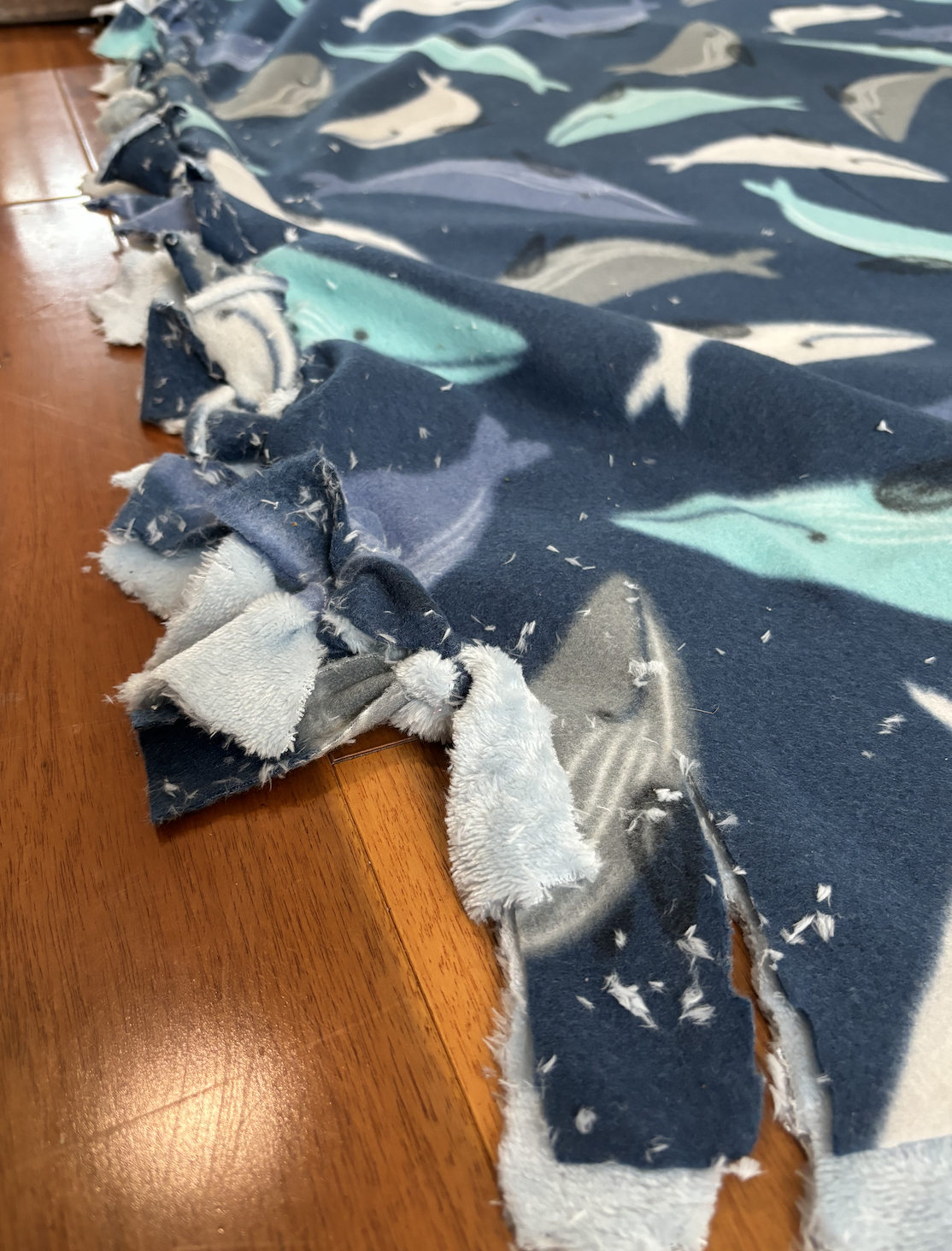 The rough knotted edges of the blanket, closed together